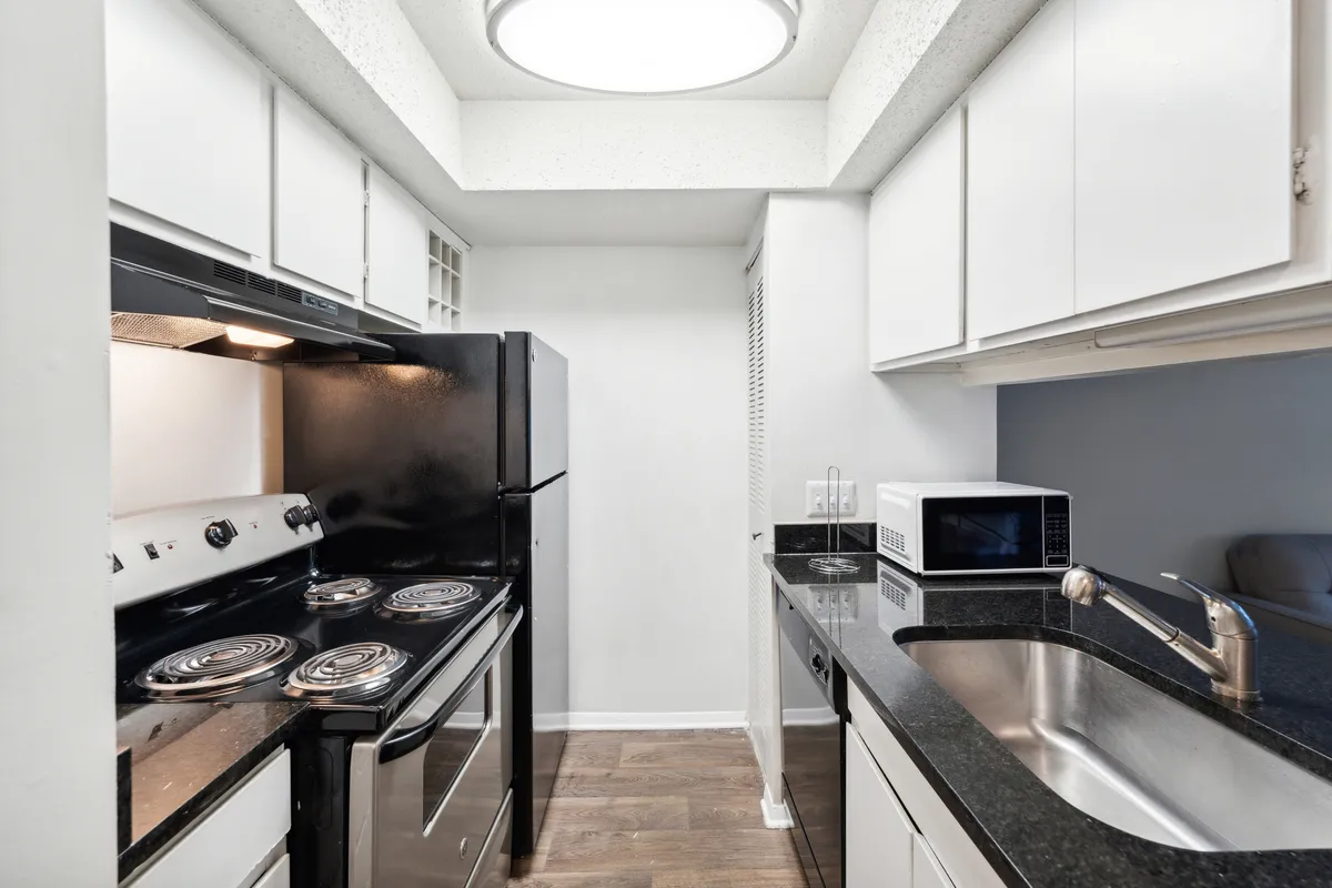 A practical and inviting kitchen space featuring a modern stove, refrigerator, sink, and generous countertop space. The layout encourages cooking and socializing, with plenty of room for meal prep or sharing snacks.